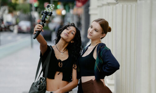 Due giovani donne che scattano un selfie in strada urbana durante un momento di viaggio