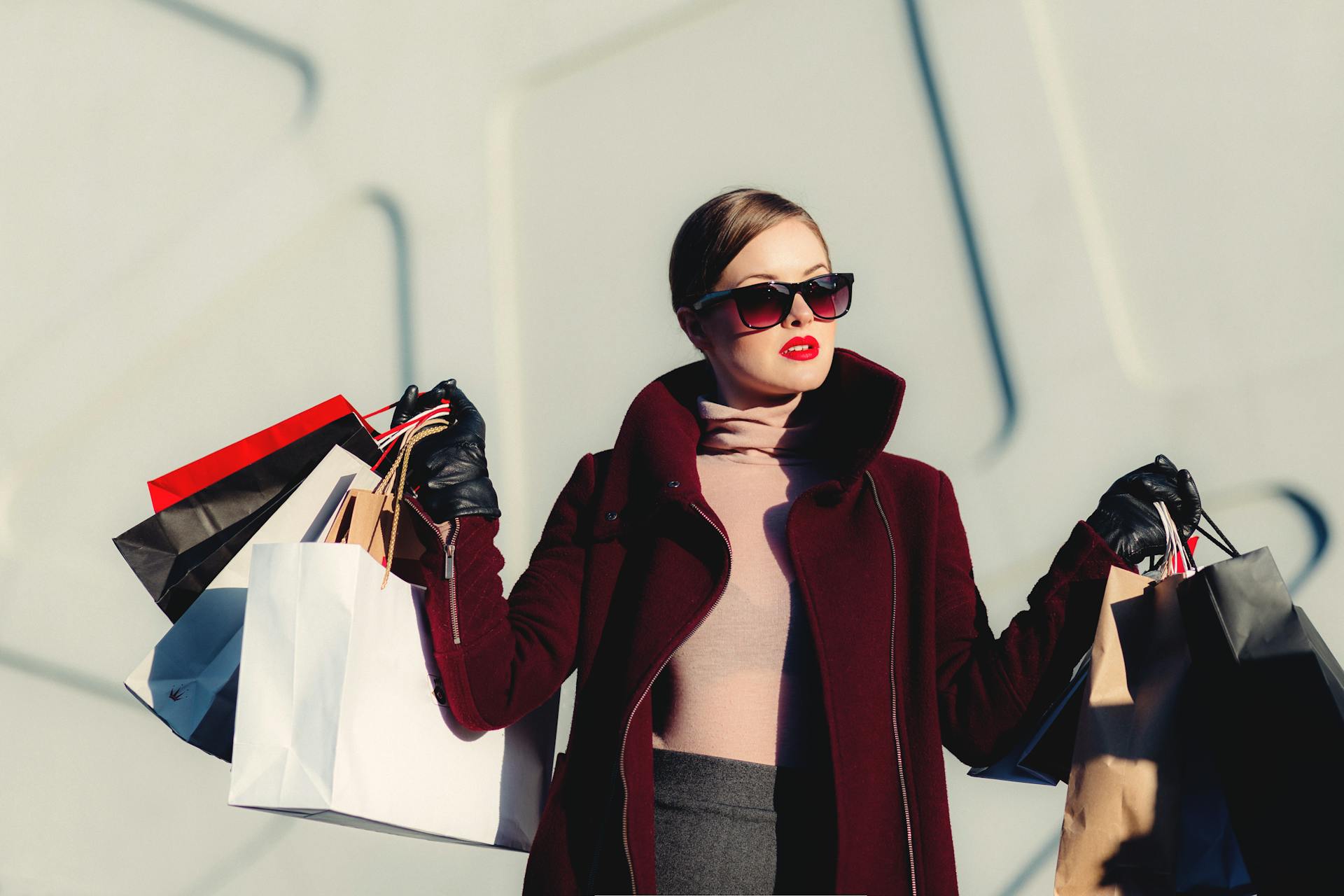 Donna elegante con buste dello shopping in ambiente urbano luminoso