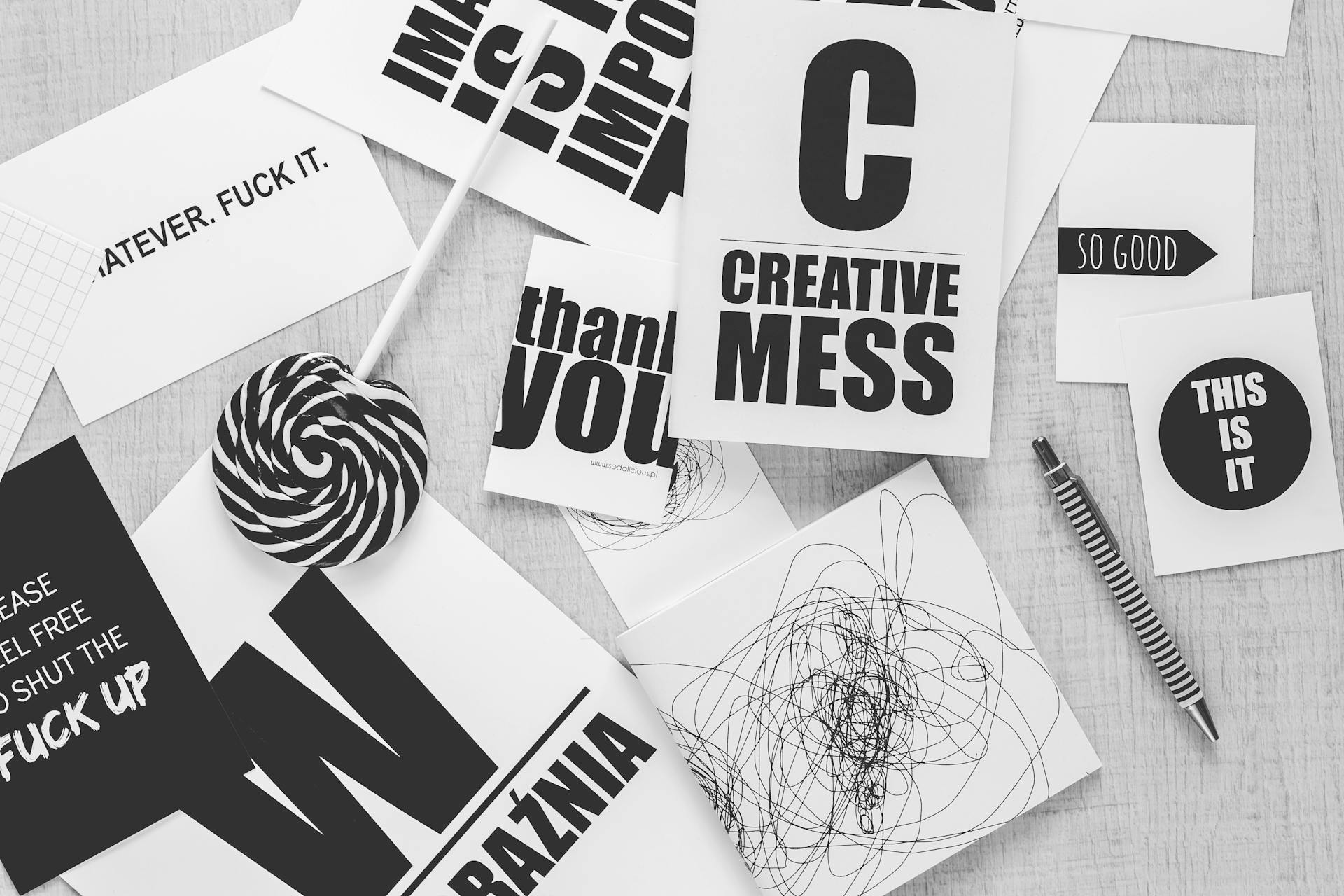 Scrivania minimal con citazioni motivazionali, penna e oggetti creativi per graphic design