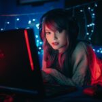 pc gaming portatile utilizzato da una ragazza in una stanza con luci soffuse durante una sessione di gioco