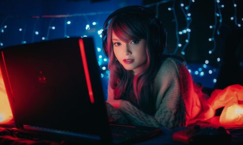 pc gaming portatile utilizzato da una ragazza in una stanza con luci soffuse durante una sessione di gioco