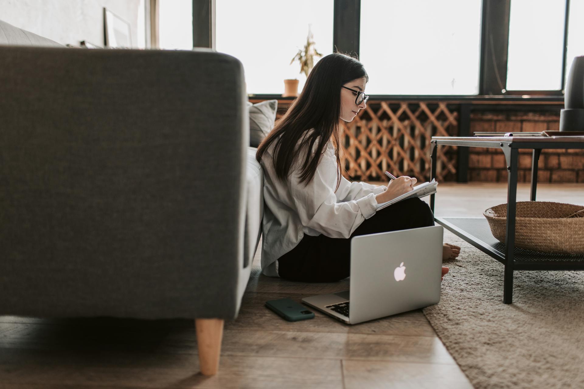 Persona al lavoro da casa su laptop in smart working con postazione digitale organizzata