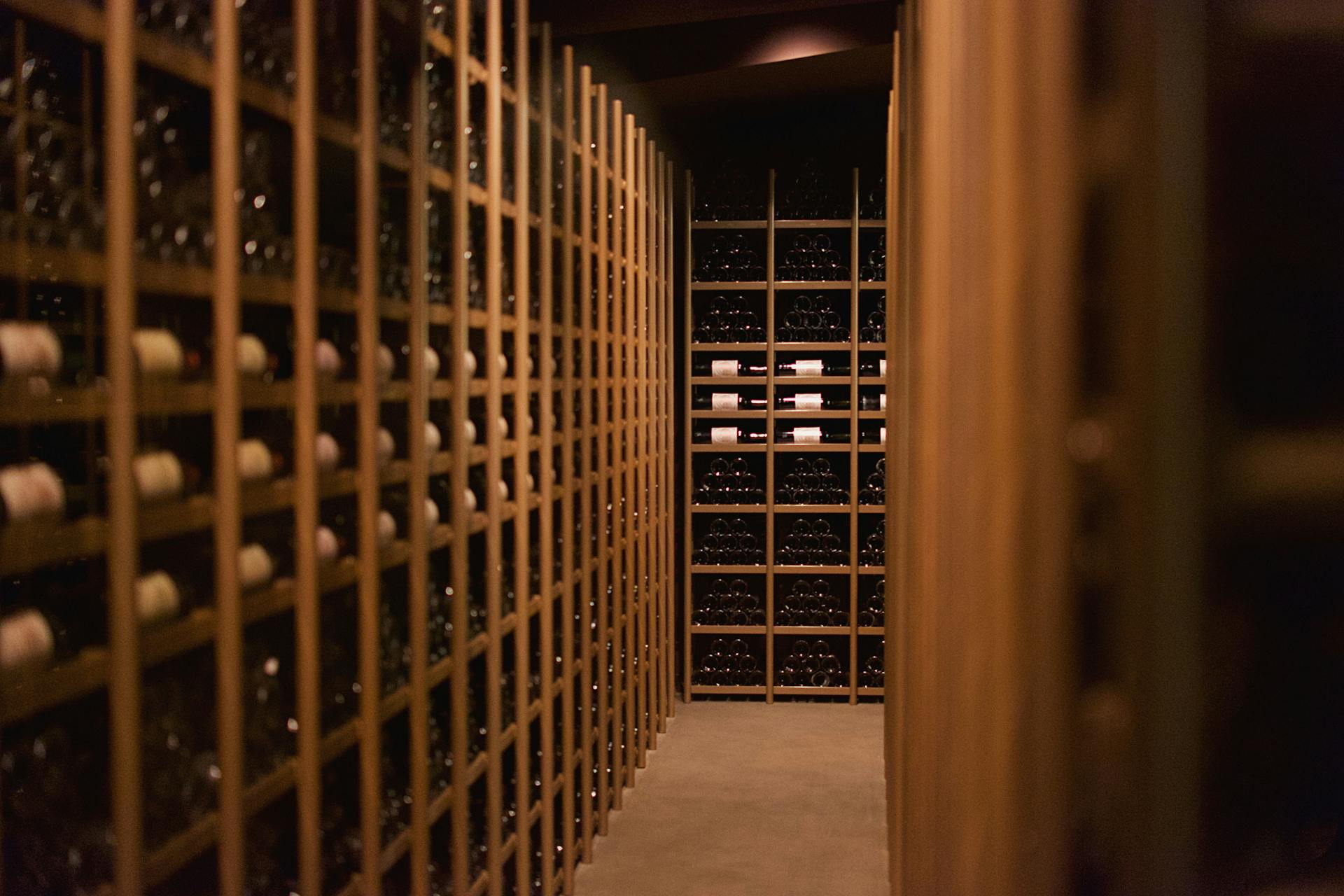 Cantina moderna in legno con scaffalature a griglia per conservazione orizzontale delle bottiglie di vino