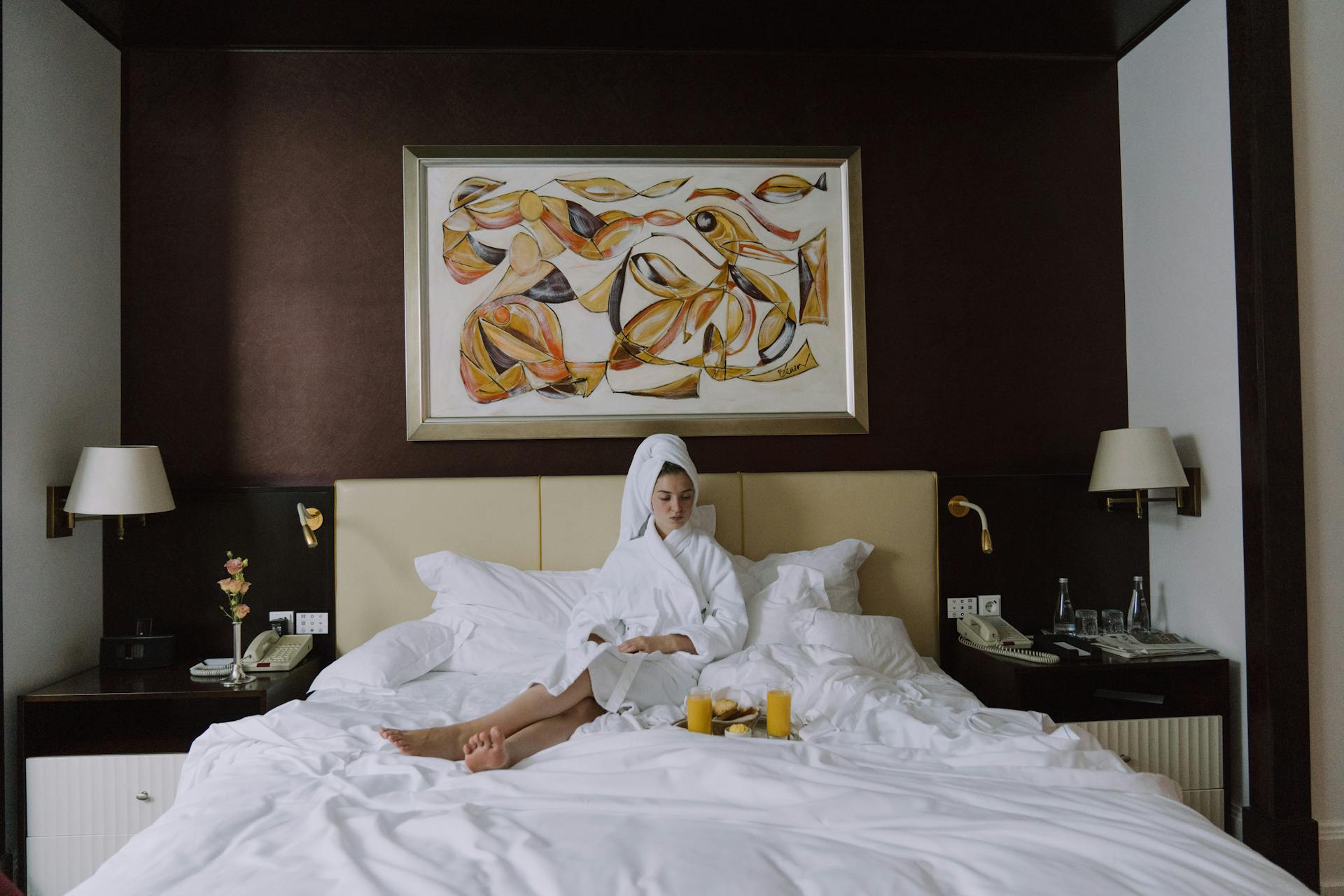 Donna in hotel di lusso che fa colazione a letto con atmosfera relax e comfort