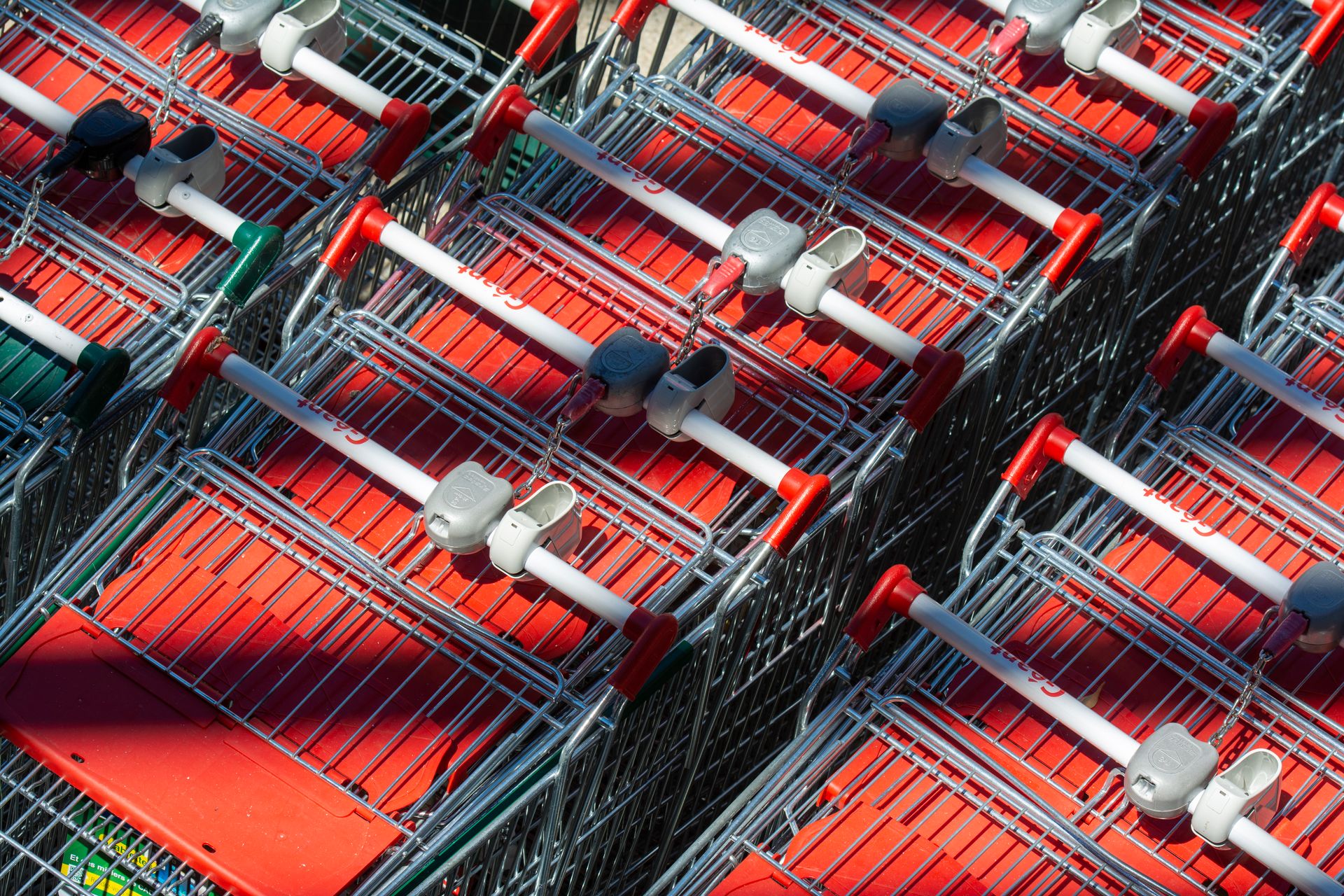 Carrelli della spesa rossi e metallici incastrati all'interno di un supermercato della grande distribuzione organizzata