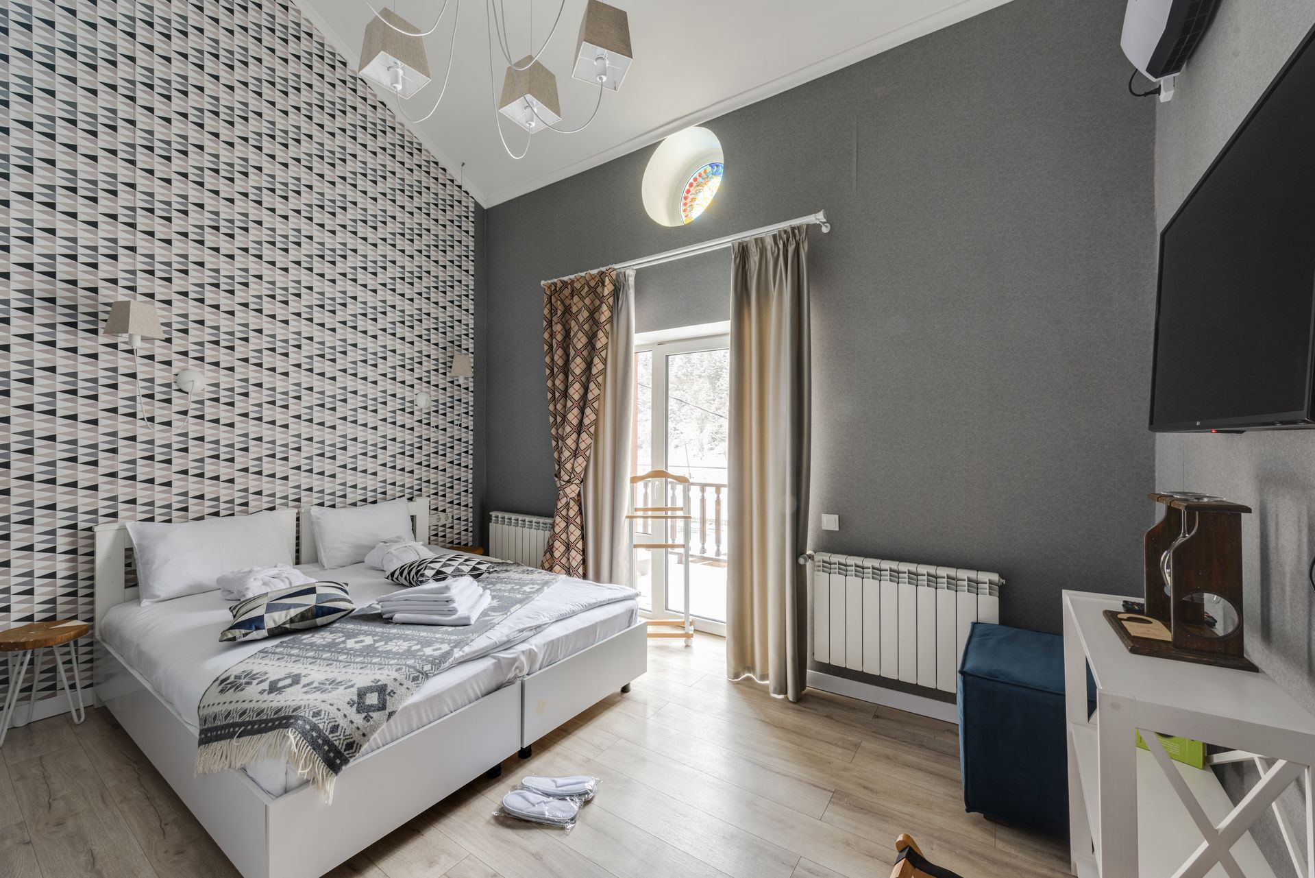 Camera da letto matrimoniale moderna e luminosa di un hotel di design con letto rifatto e finestra sul balcone