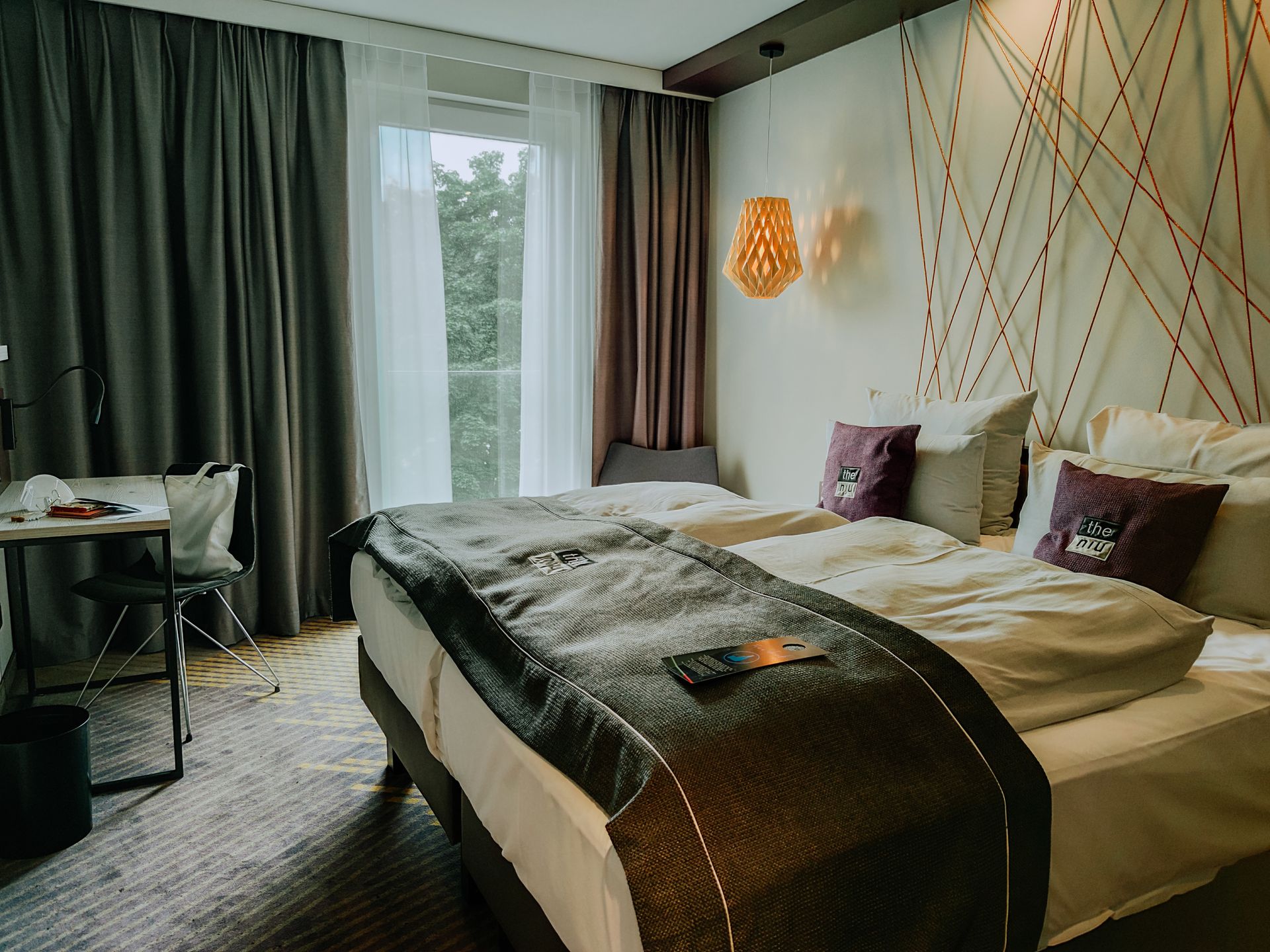 Camera da letto di un hotel a Trani con letto matrimoniale rifatto e arredamento moderno ed elegante.