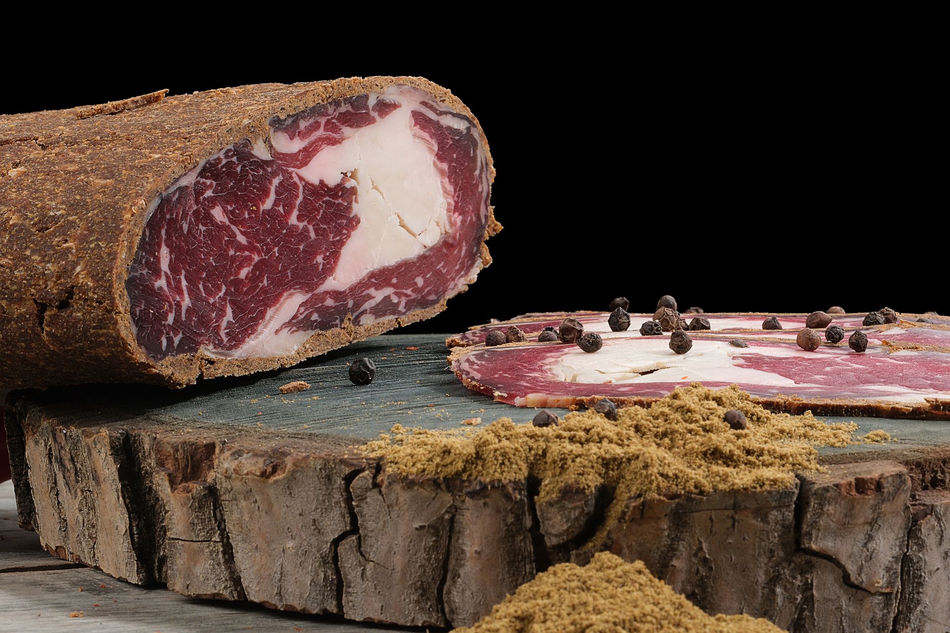 Salume stagionato tipico su tagliere di legno per norcinerie e salumifici