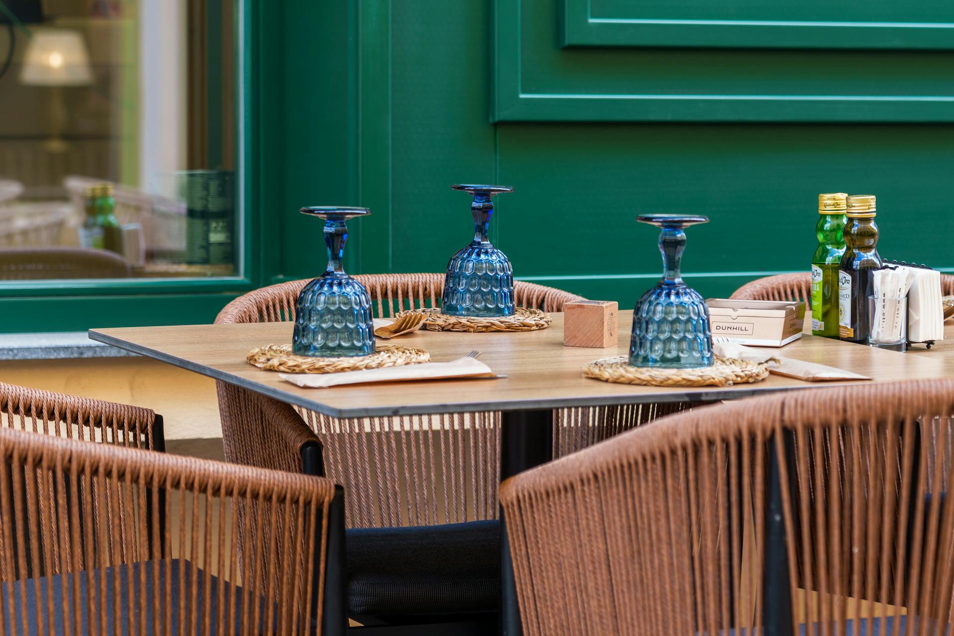 Tavola apparecchiata in un ristorante di Canosa di Puglia con bottiglie di olio extravergine e calici blu